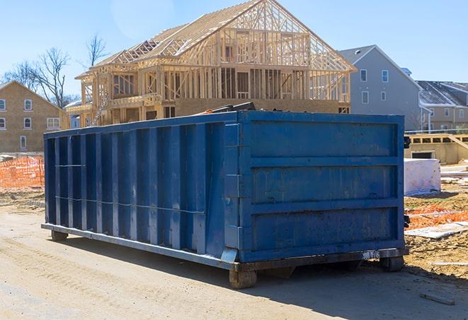 dumpsters with hinged lids parked in front of a city apartment building